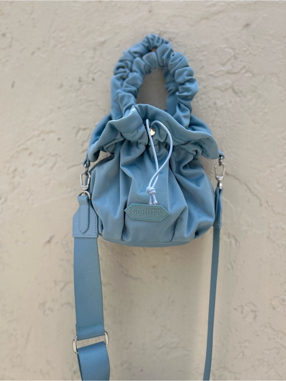 Schutz Lolla Stretch Nylon Bucket Bag in a light blue shade.